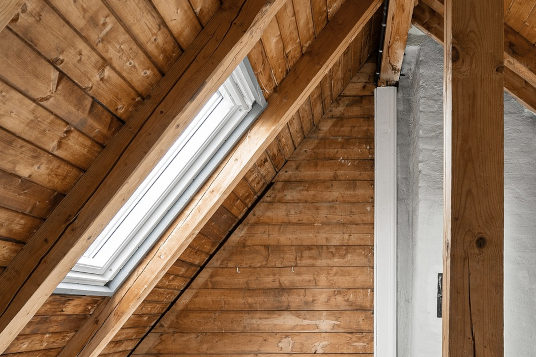 Modernes Dachfenster in einem Holzleisten ausgebauten Dach.