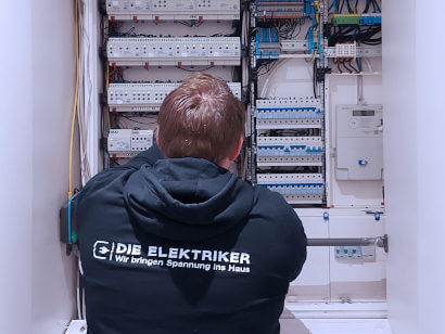Mitarbeiter von Die Elektriker bei der Elektroinstallation in einem Verteiler