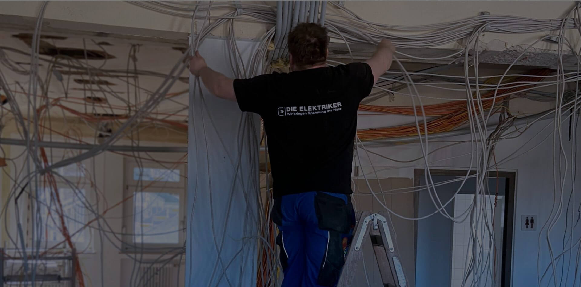 Andreas Stroh bei der Installation von Kabeln in einem Raum