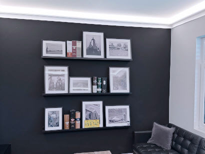 Raum als Referenz mit Deckenbeleuchtung und schwarze Wand mit Regal mit Bilder